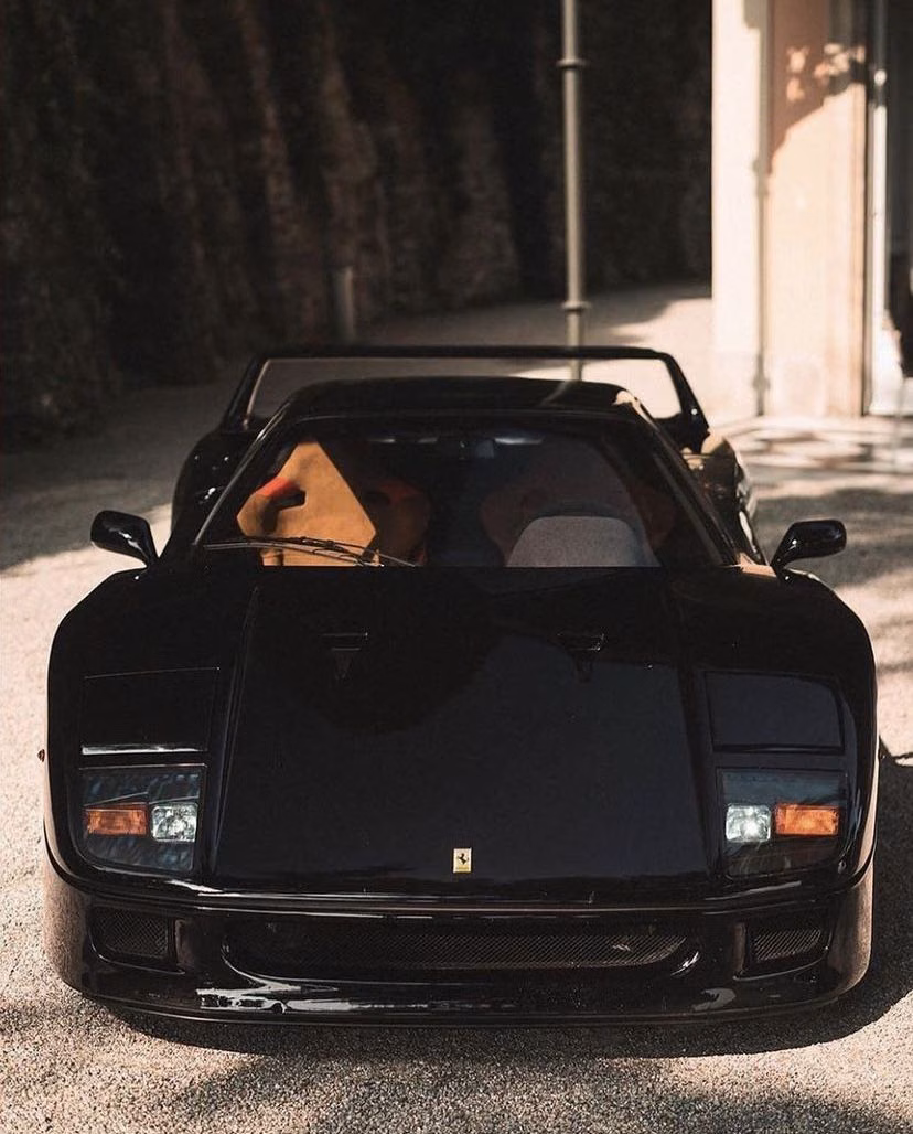 A black sports car parked in front of a building.