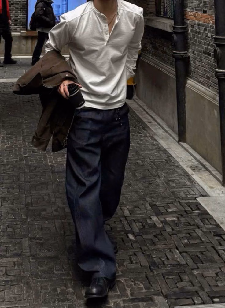 A formal menswear outfit in dark, classic layers.
