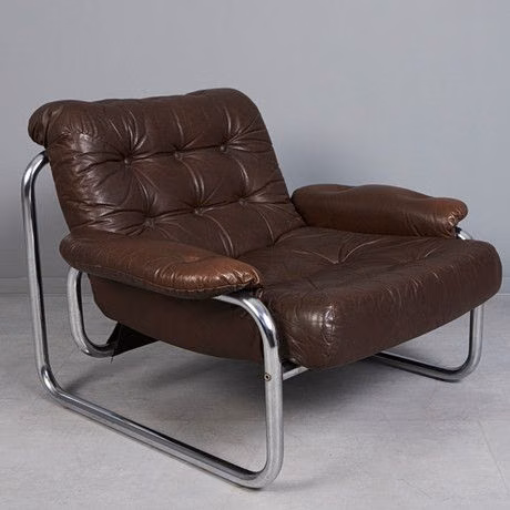 A brown leather armchair with chrome legs.