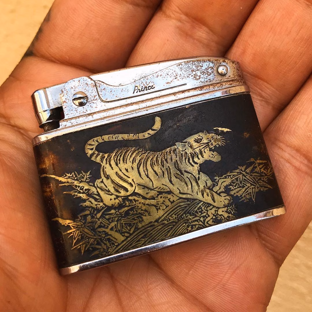 A vintage 1950s lighter with a raised tiger motif.